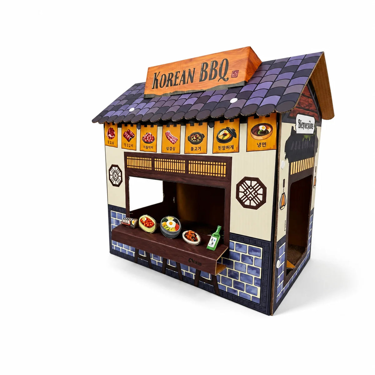 A miniature cardboard Korean BBQ restaurant playset on a white background, featuring a detailed roof, food display counter with toy dishes, and signage.