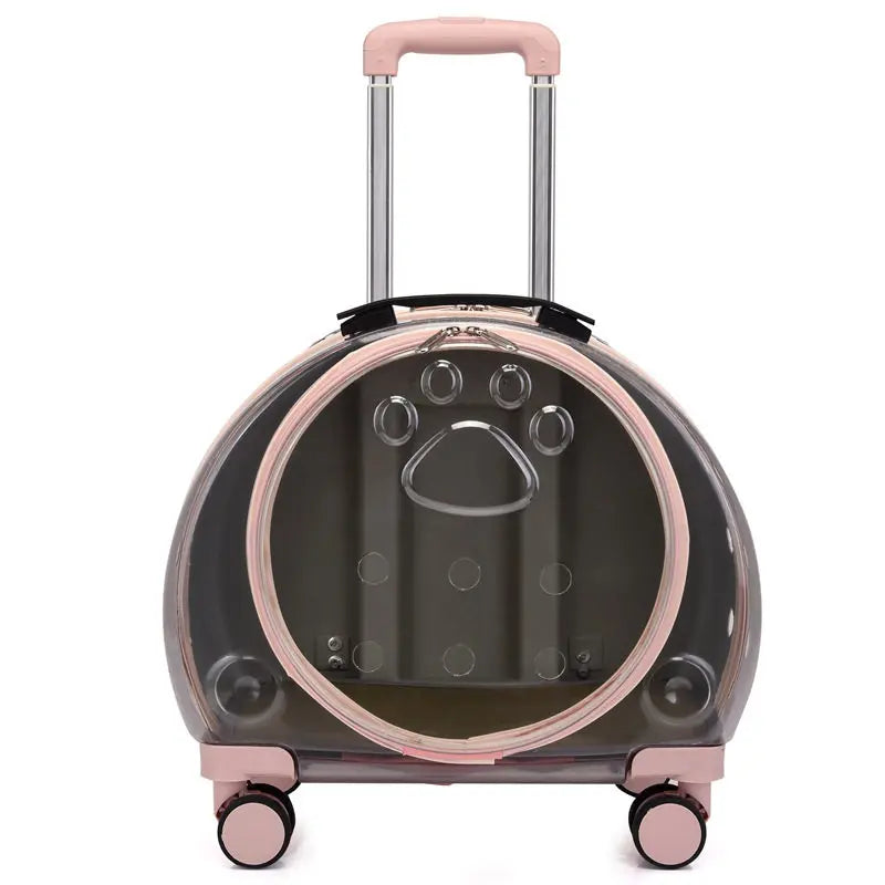 A clear pet cat carrier suitcase with a pink handle and wheels, featuring a paw print design on the front window.