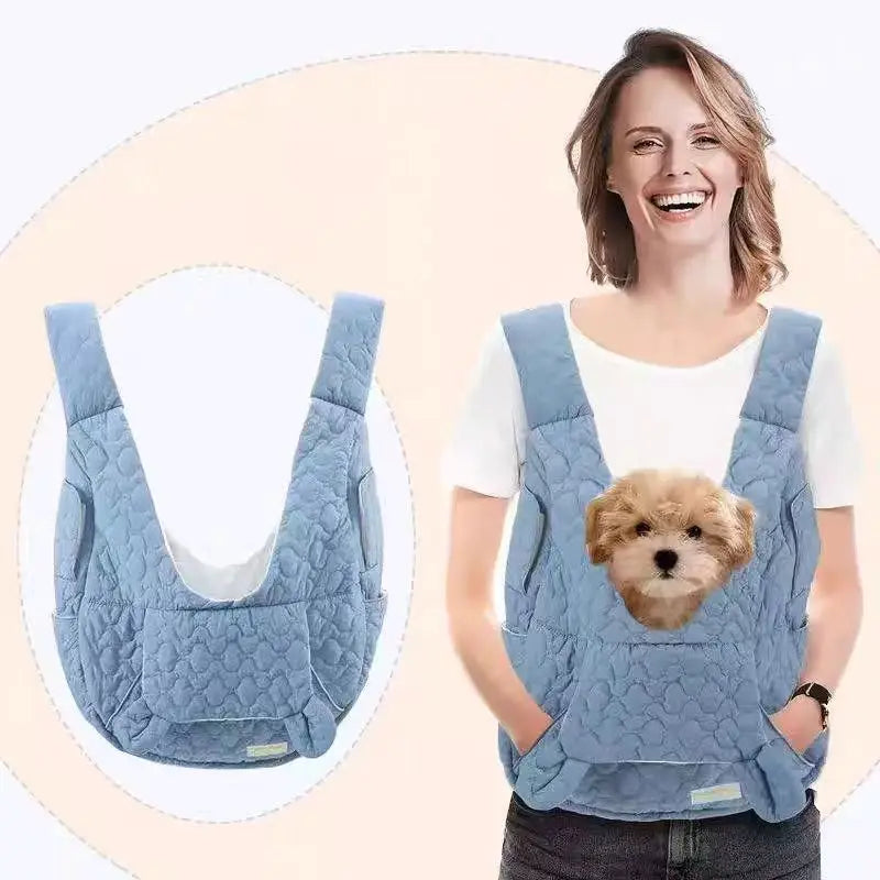 Woman wearing a blue pet carrier with a dog inside, on a beige background.