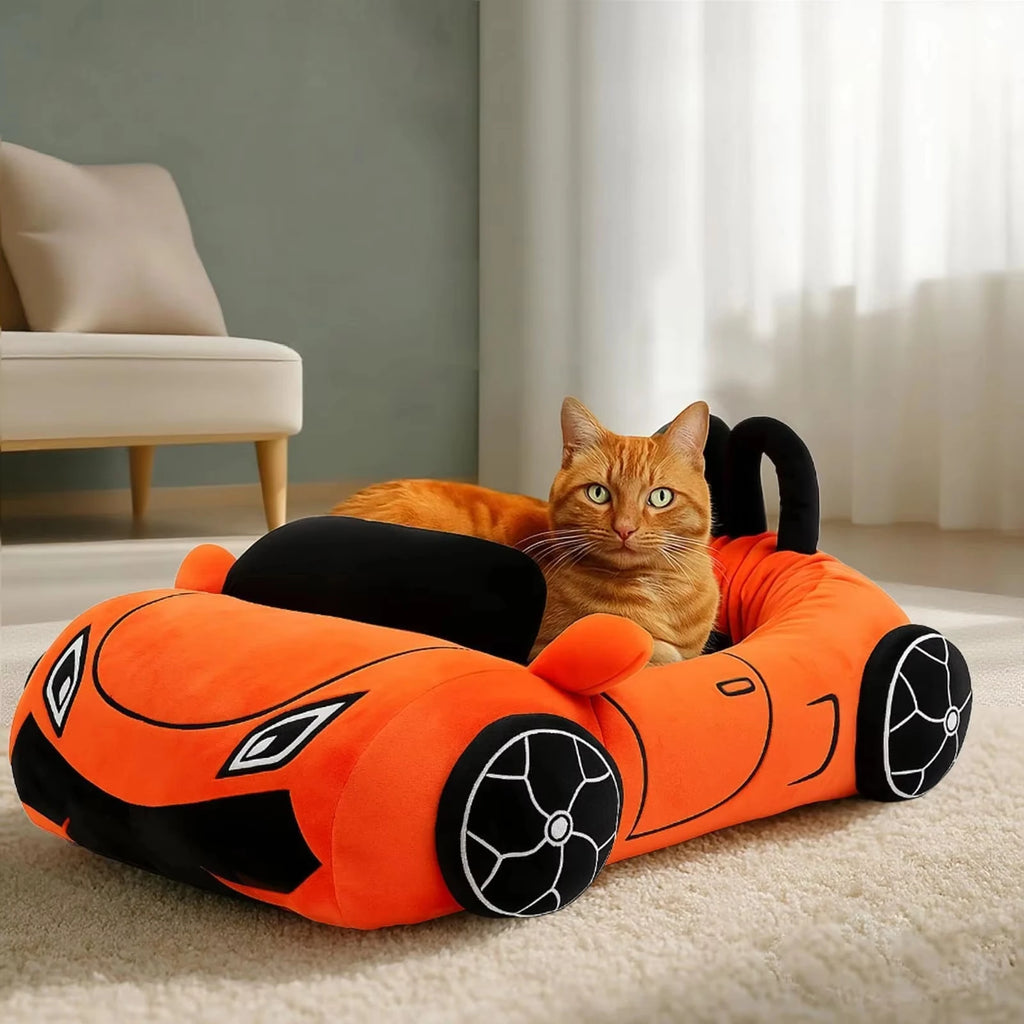 Cat lying on an orange car-shaped pet bed in a room with a couch and curtains.