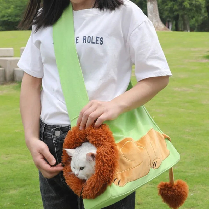 Person holding a green bag with a lion design, featuring a cat inside, outdoors.