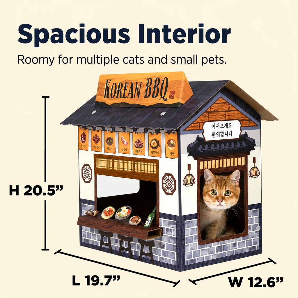 A decorative cat house shaped like a Korean BBQ restaurant, shown with dimension lines and text reading 'Spacious Interior' and measurements in inches. A real cat is visible inside one window opening.