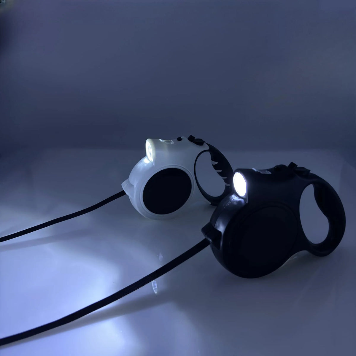 Retractable dog leashes with lights on a dark background