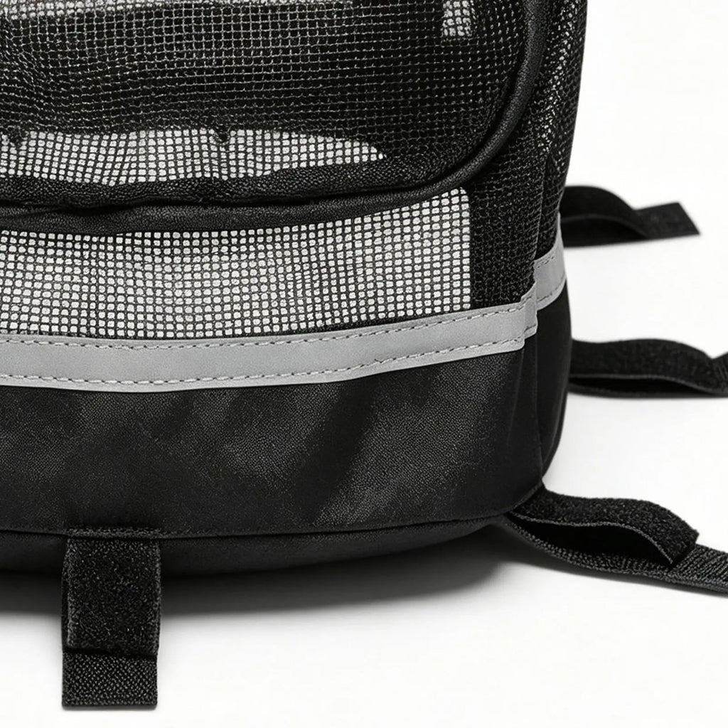 Close-up of a black mesh backpack or pet carrier with a reflective gray horizontal stripe and black webbing straps on a white background.