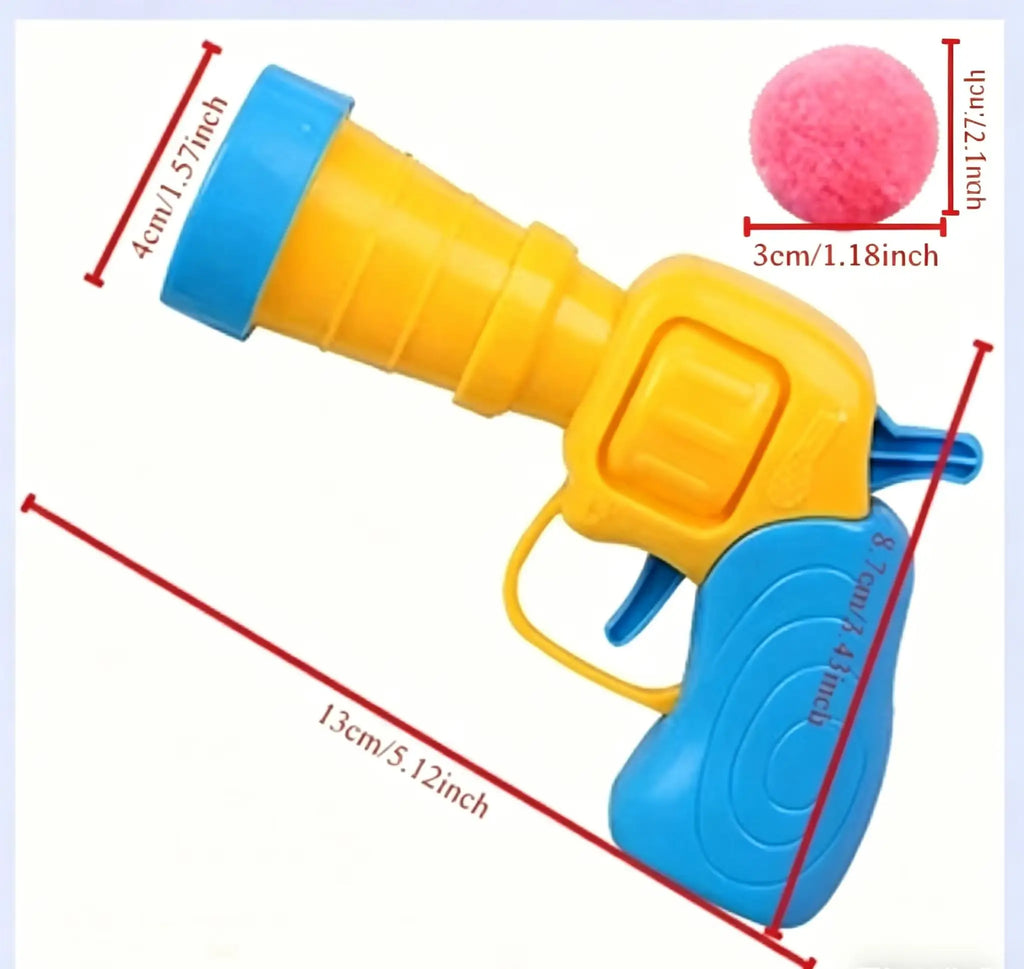 A yellow and blue plastic toy gun shown with red dimension lines and text labels indicating measurements, plus a pink ball accessory in the top right on a white background.