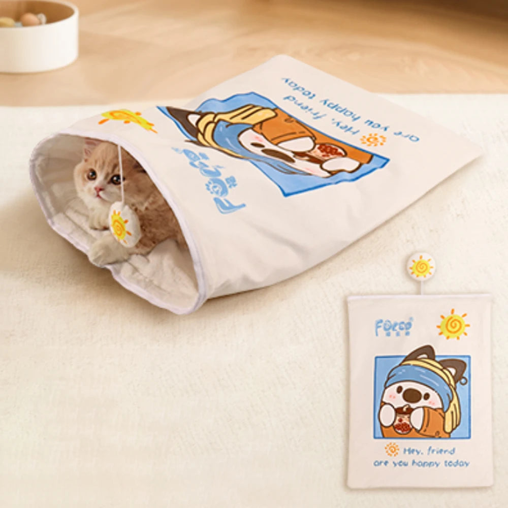 Cat playing with a tunnel toy featuring cartoon designs on a light surface.