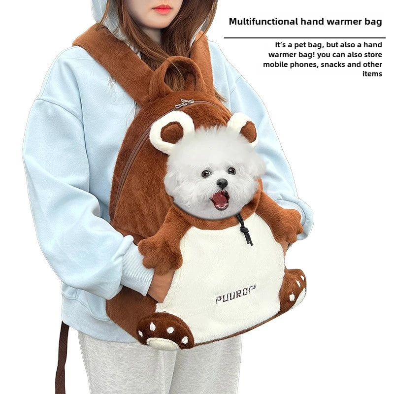 A person wearing a light blue hoodie holds a plush brown and cream pet backpack with a small white dog inside. Text on the right reads 'Multifunctional hand warmer bag' and describes storage use.