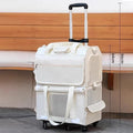 Stack of two white suitcases with wheels on a wooden bench background