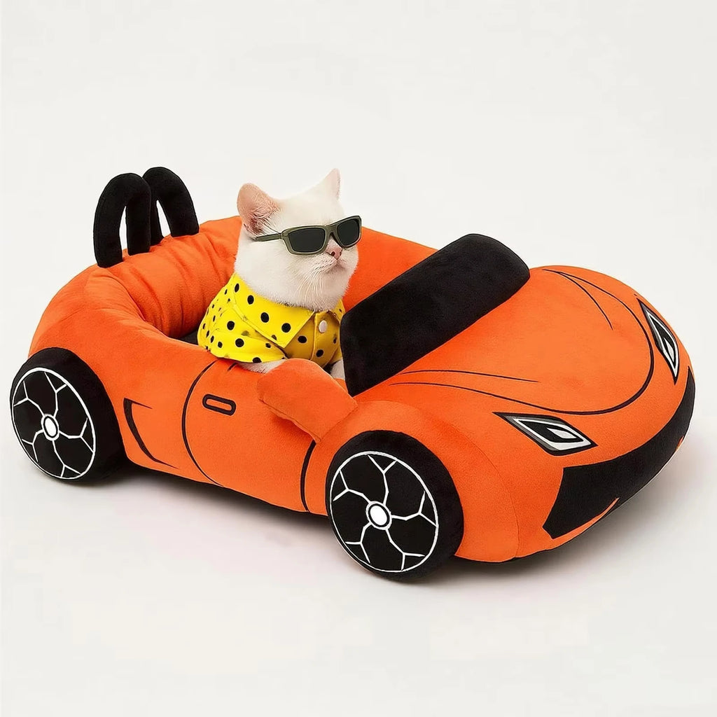 Cat wearing sunglasses inside an orange car-shaped pet bed on a white background