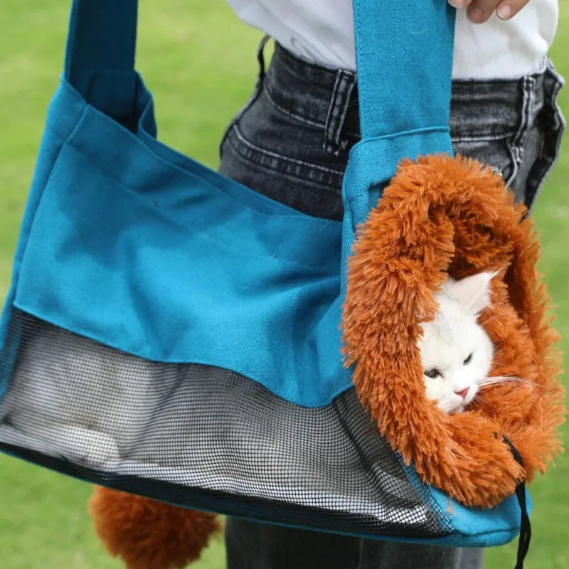 Cat in an orange plush lion costume held by a blue bag with a green background